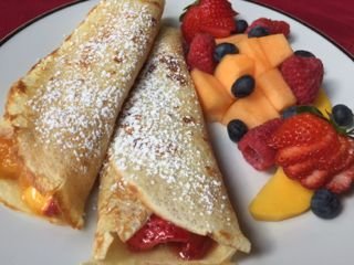 Image of strawberry, and peach crepes, with side of fresh fruit