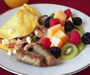 Custom made omellete with side of fresh fruit and sausge